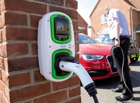Man charging electric car on his home driveway